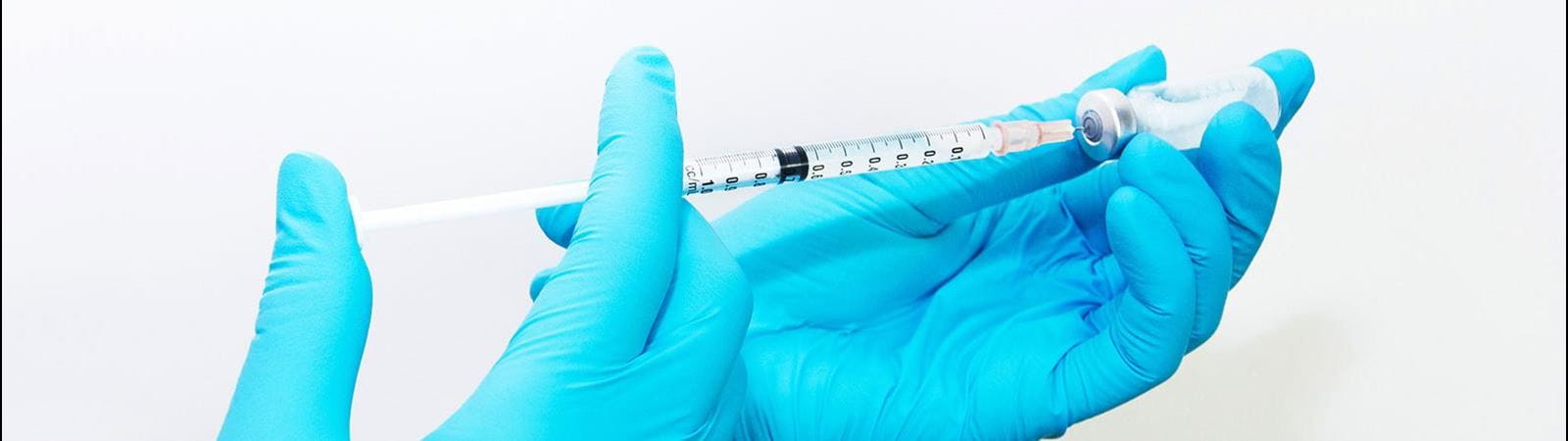 Mano che tiene siringa e fiala